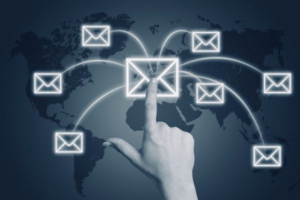 Communication concept Communication concept: Hand pressing a letter icon on a world map interface